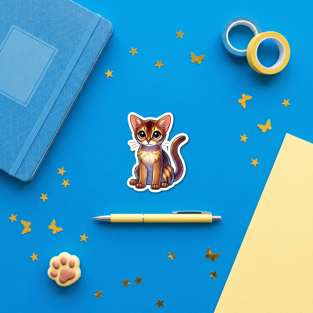 Abyssinian Ruddy Kawaii Magnet in a blue flat lay