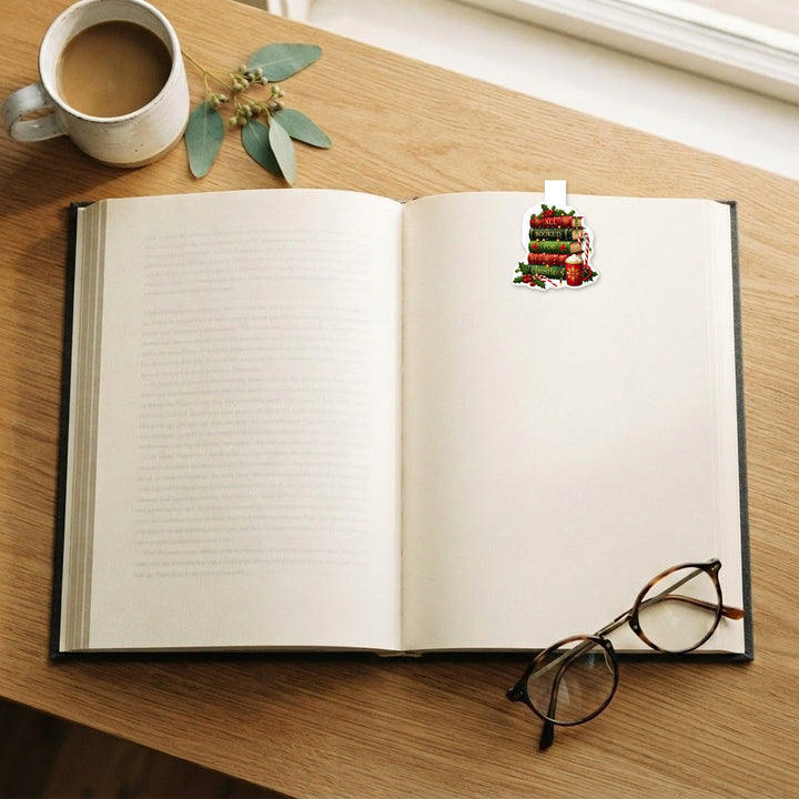All Booked for Christmas book stack magnetic bookmark on an open book on a wooden desk with coffee and reading glasses