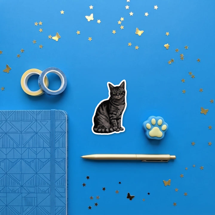 American Shorthair Black Tabby watercolor 3 inch sticker flat lay with blue and yellow stationery – Designs by Mysh