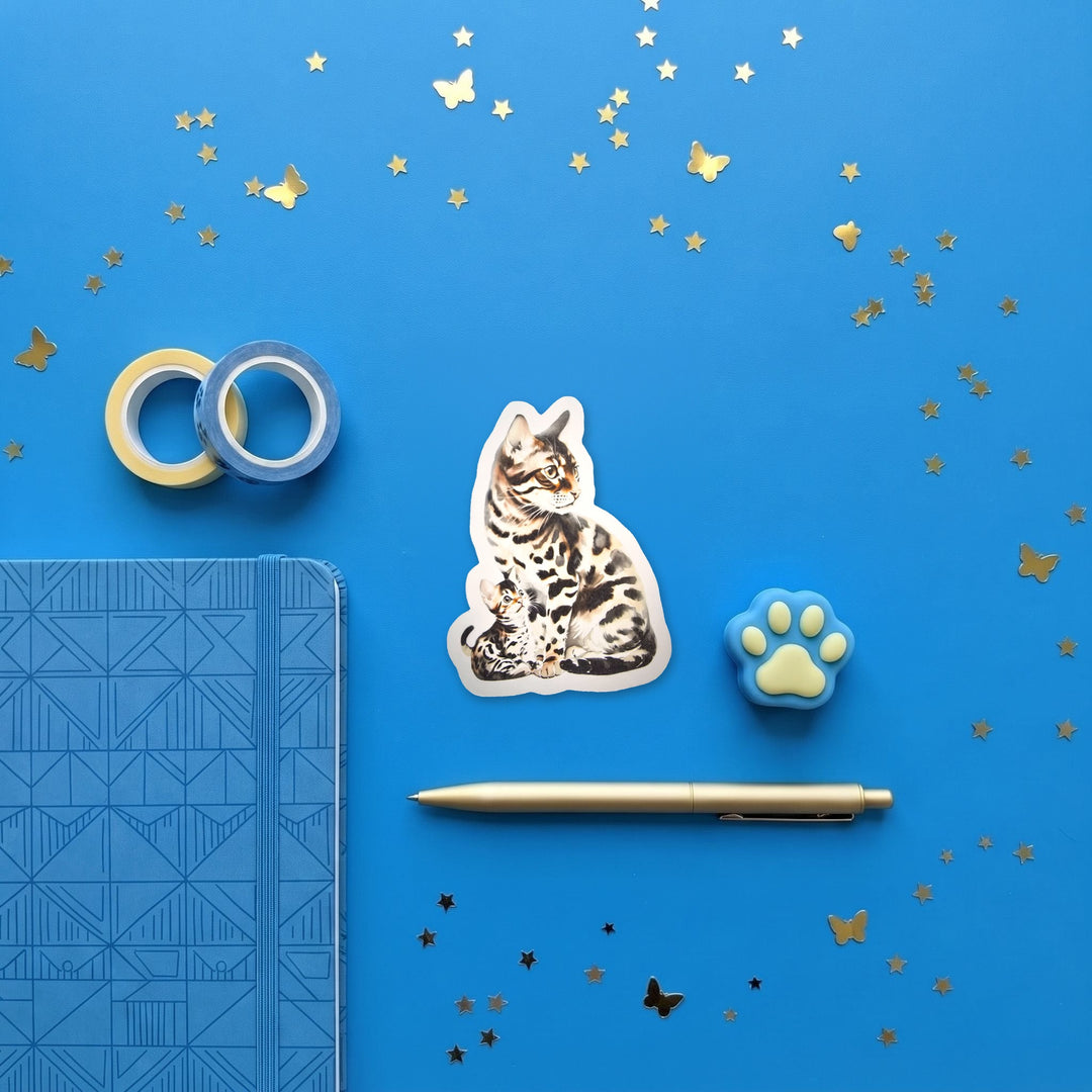 Bengal cat and kitten sticker in a blue flat lay with washi tape and a pen