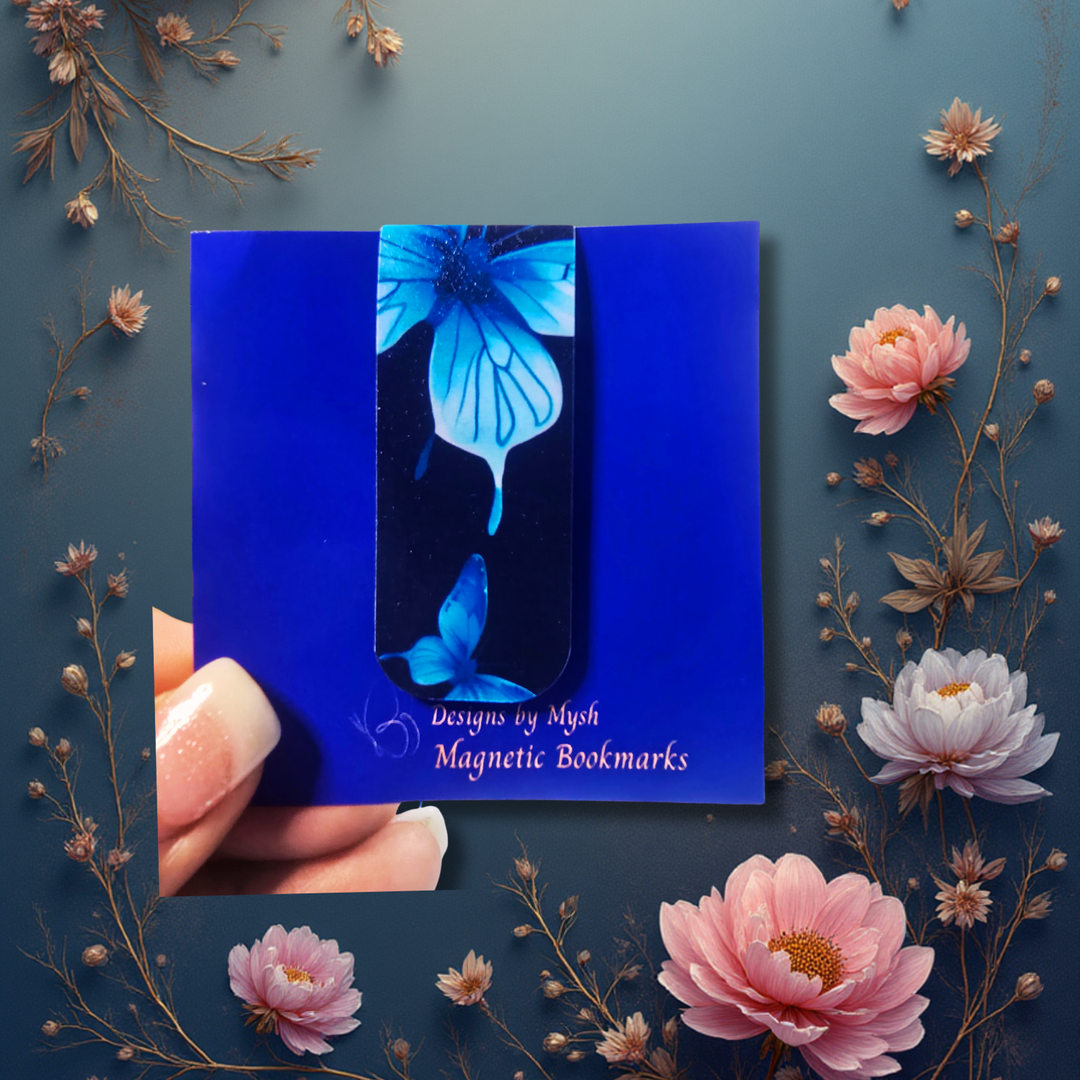 Blue magnetic bookmarks with butterfly design held between pink and white flowers on a blue background
