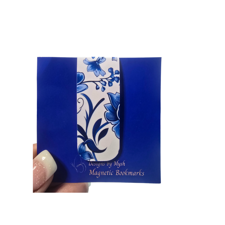 Blue floral magnetic bookmarks packaging held by a hand on a white background