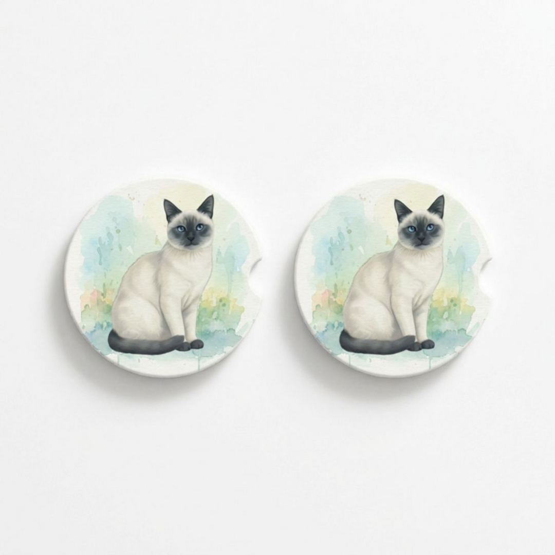 Set of two round ceramic car coasters featuring a watercolor-style illustration of a Siamese cat with a blue point coat.