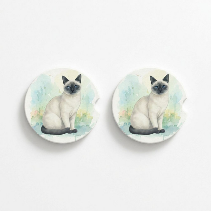 Set of two round ceramic car coasters featuring a watercolor-style illustration of a Siamese cat with a blue point coat.