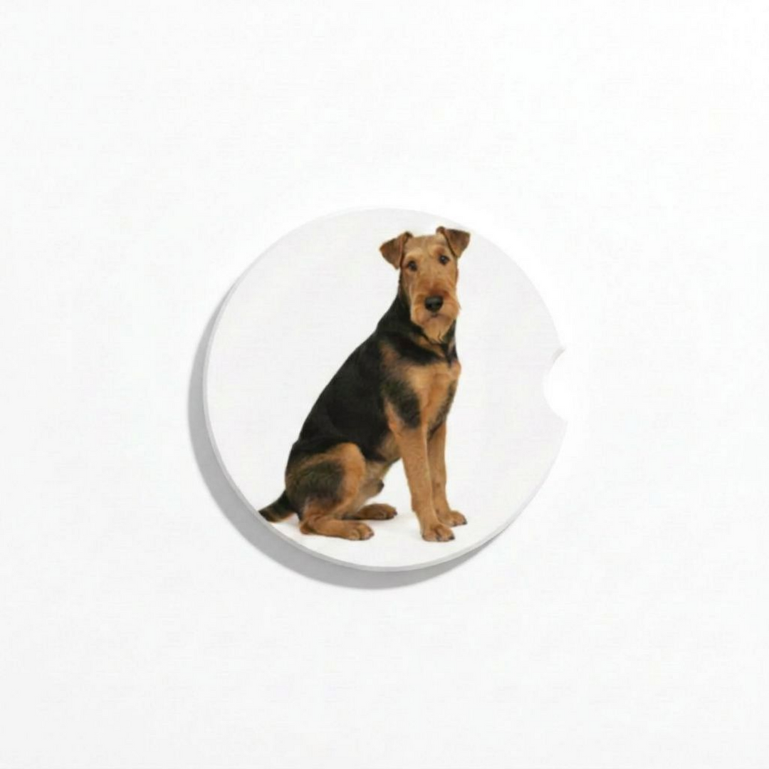 Single round ceramic car coaster featuring a watercolor-style illustration of an Airedale Terrier with a black and tan coat, sold individually.
