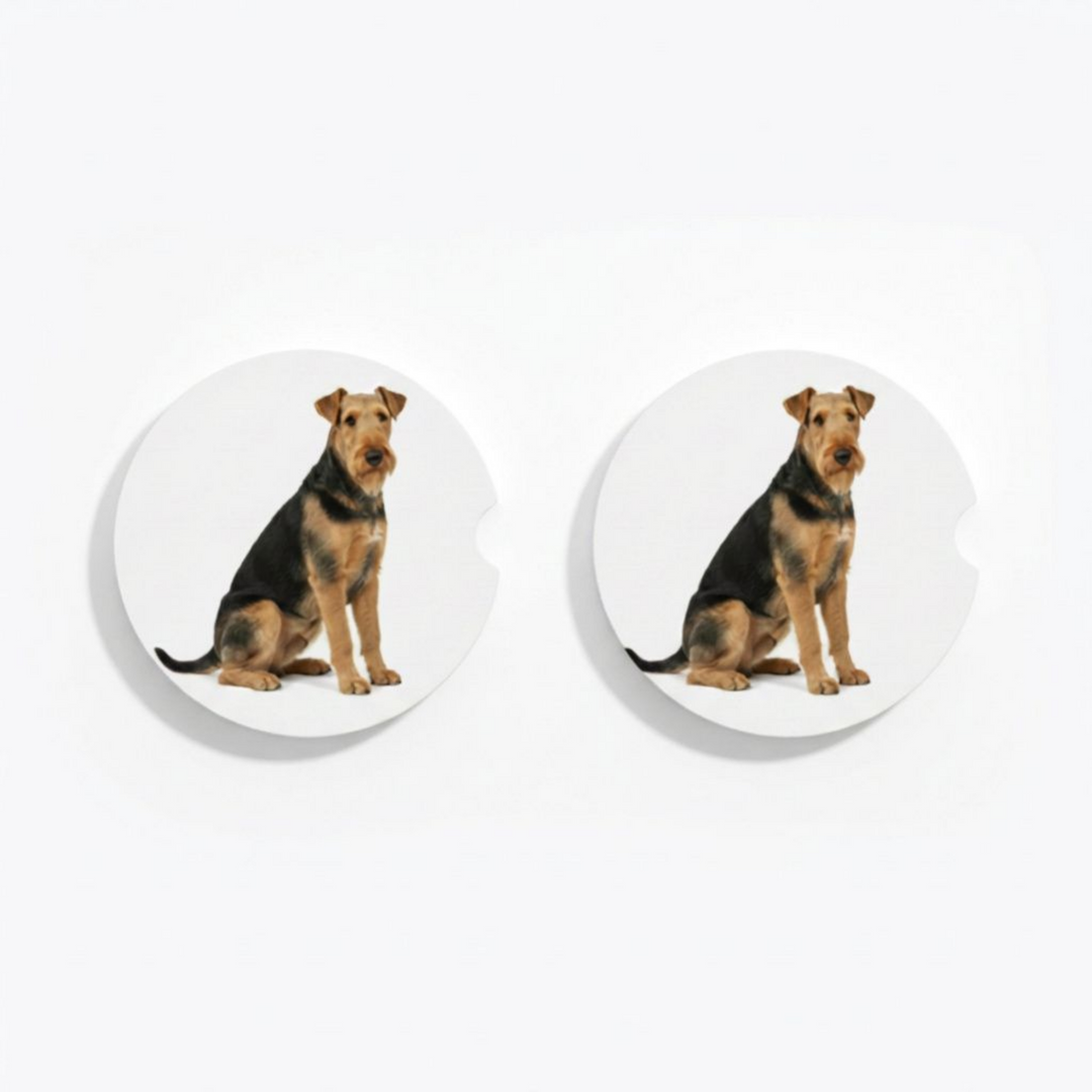 Set of two round ceramic car coasters featuring a watercolor-style illustration of an Airedale Terrier with a grizzle and tan coat.