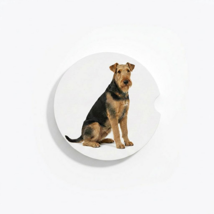 Single round ceramic car coaster featuring a watercolor-style illustration of an Airedale Terrier with a grizzle and tan coat, sold individually.