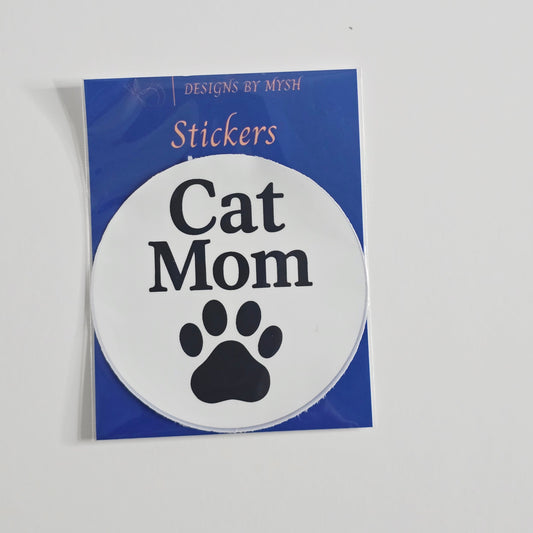 "3-inch round vinyl sticker with the words 'Cat Mom' in bold black letters and a black paw print underneath on a white background."