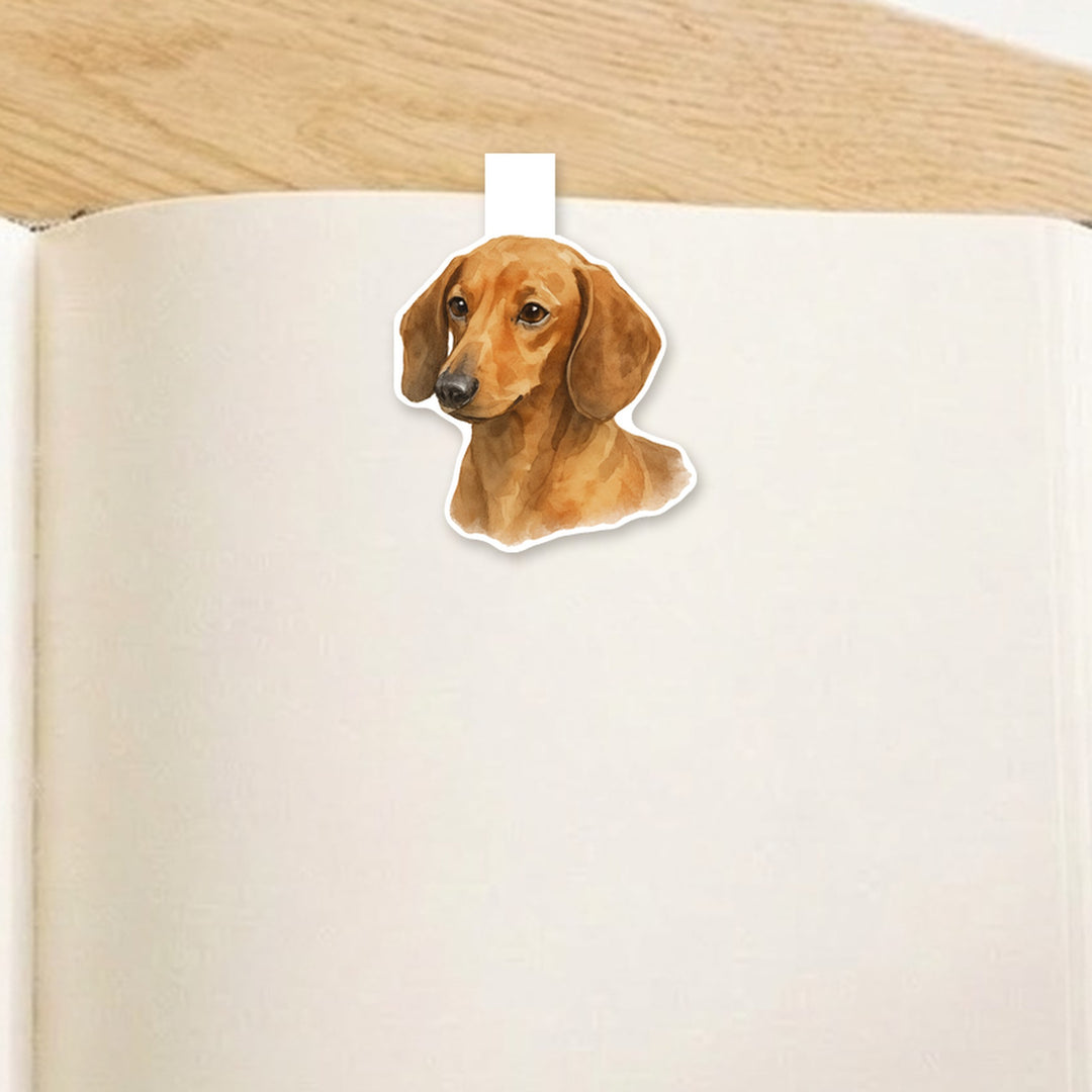 Dachshund watercolor magnetic bookmark clipped over the top of an open book page – Designs by Mysh