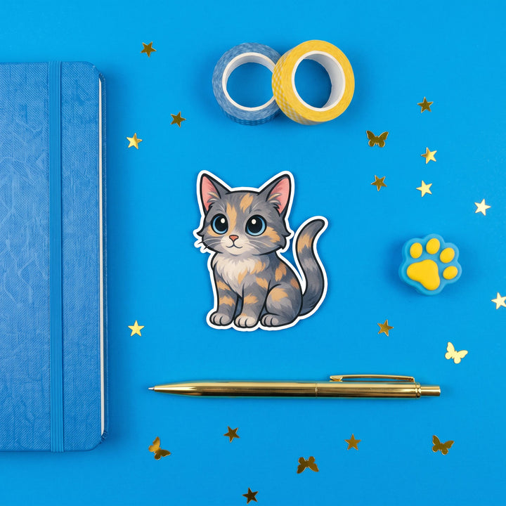 Dilute Tortoiseshell Kawaii Magnet in a blue flat lay