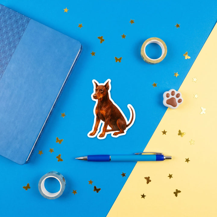 Doberman Red Rust Watercolor Sticker in a blue flat lay
