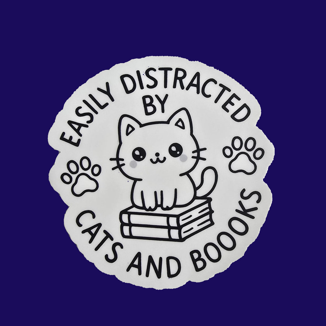 "Die-cut vinyl sticker with a black-and-white kawaii cat sitting on books, surrounded by the text 'Easily Distracted by Cats and Boooks' and two paw prints."