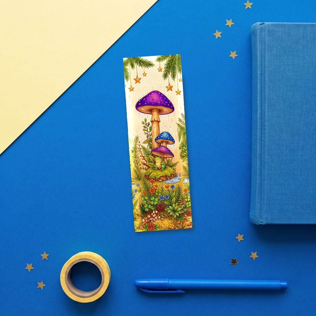 Frog Mushroom Umbrella 2x6 inch bookmark flat lay with blue book and stationery - Designs by Mysh