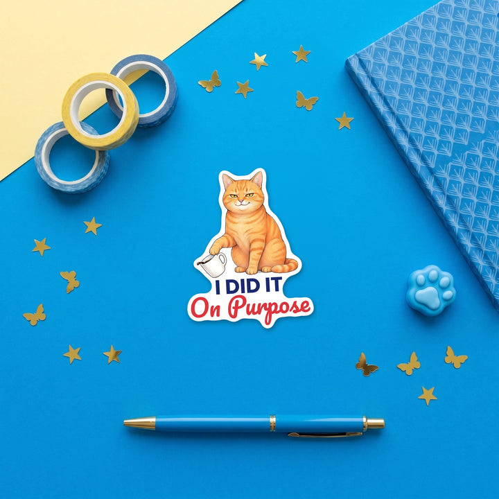I Did It On Purpose orange cat sticker in a blue flat lay with washi tape and a pen