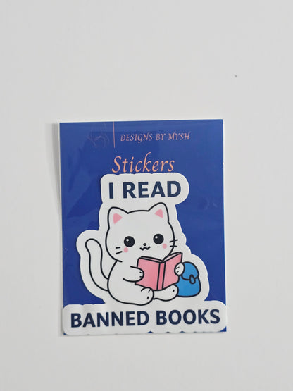 "Vinyl sticker featuring a white cartoon cat reading a pink book with the phrase 'I Read Banned Books' in bold text, 3-inch waterproof die-cut sticker."