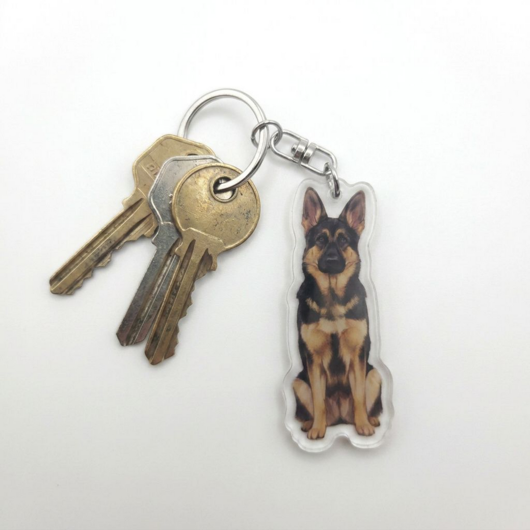 Black and tan German Shepherd acrylic keychain attached to a keyring with house keys