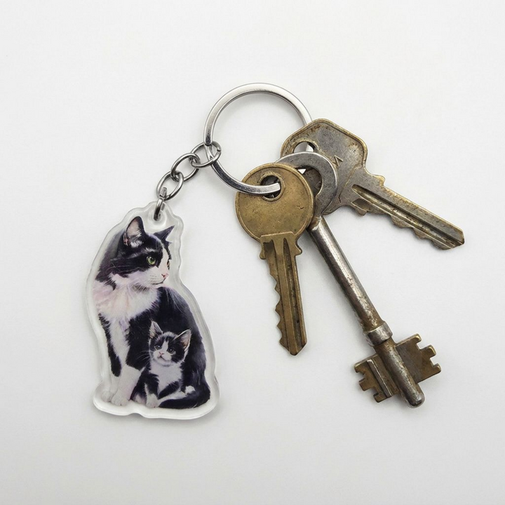 Tuxedo cat and kitten acrylic keychain attached to a keyring with house keys