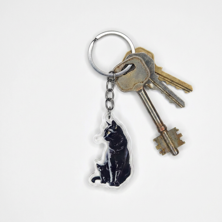 Black cat and kitten acrylic keychain attached to a keyring with house keys