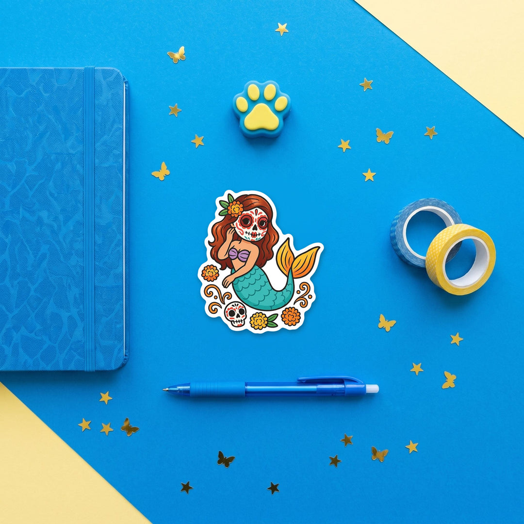 Marigold sugar skull mermaid 3 inch sticker flat lay with blue and yellow stationery – Designs by Mysh