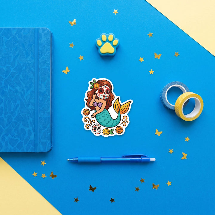 Marigold sugar skull mermaid 3 inch sticker flat lay with blue and yellow stationery – Designs by Mysh