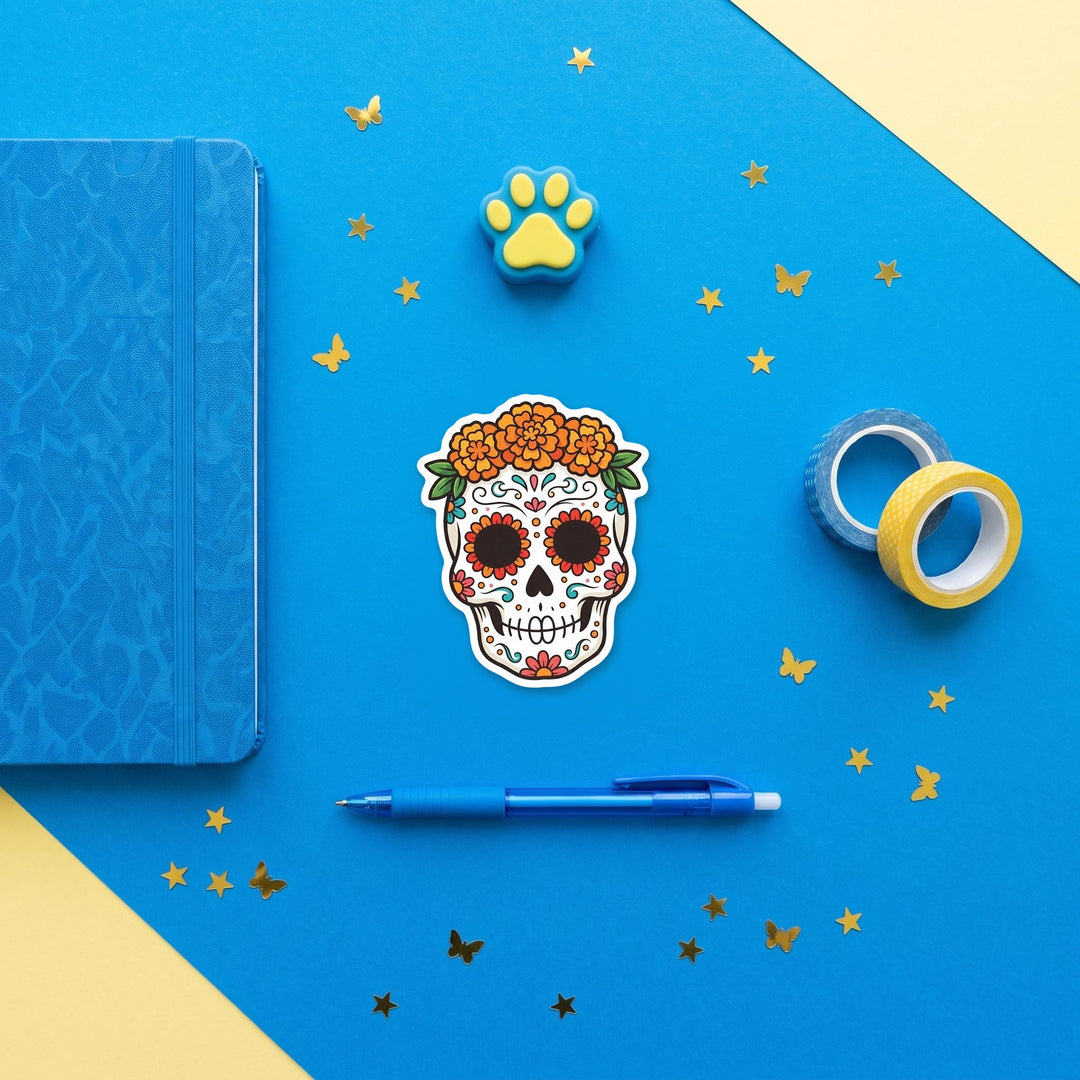Sugar skull with marigold crown 3 inch sticker flat lay with blue and yellow stationery – Designs by Mysh