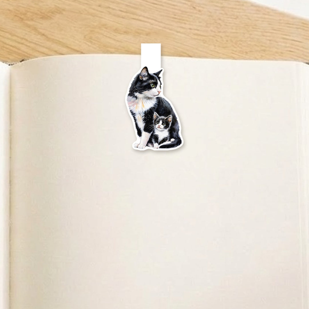 Tuxedo mama cat and kitten magnetic bookmark clipped over the top of an open book page – Designs by Mysh