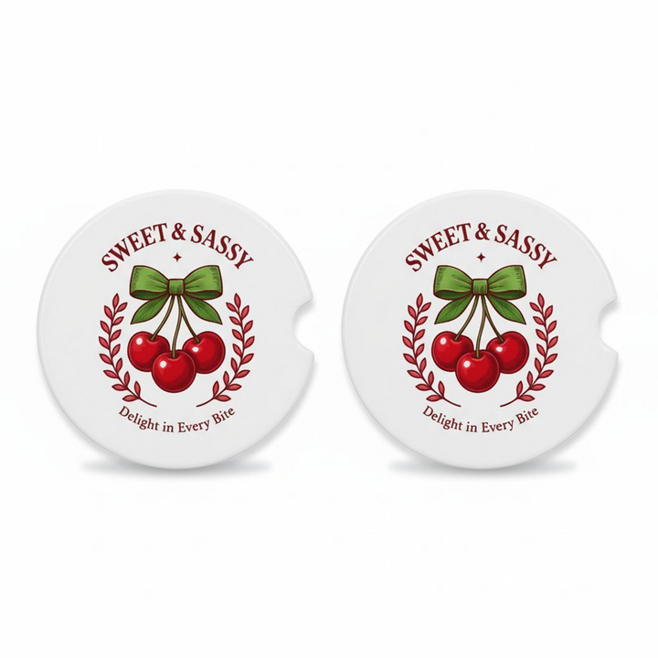 Set of two ceramic car coasters with a retro cherry design, green bow, and the phrases “Sweet &amp; Sassy” and “Delight in Every Bite,” printed on a white background.
