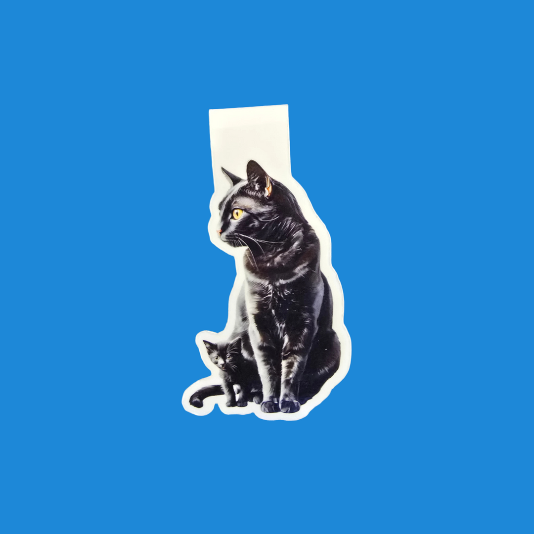 A die-cut sticker featuring a black cat and a small kitten, shown against a solid blue background.