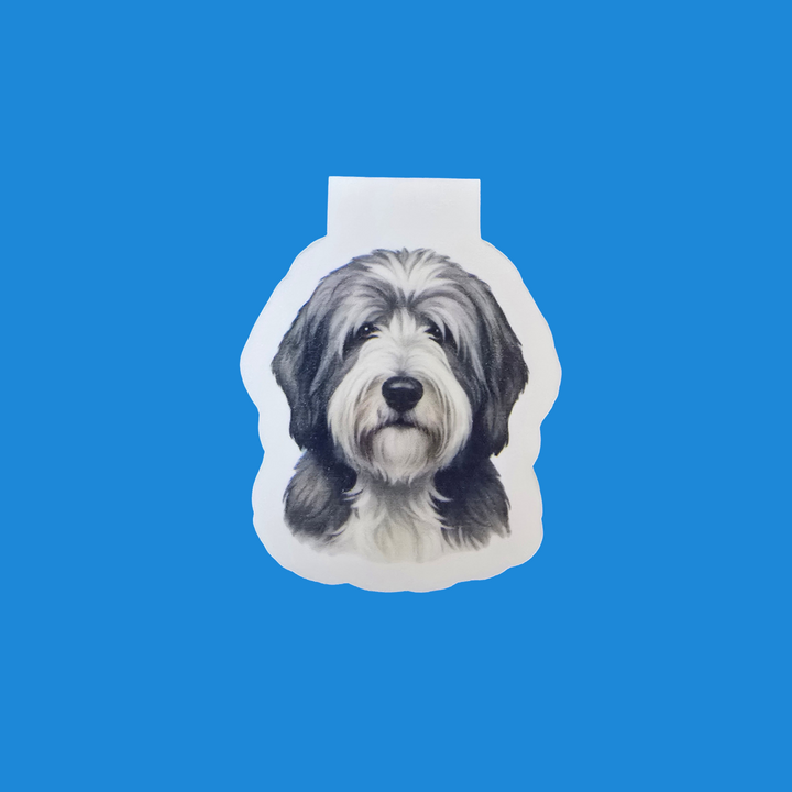 A custom die-cut sticker featuring a black and white sketch portrait of a fluffy dog, shown on a solid bright blue background.
