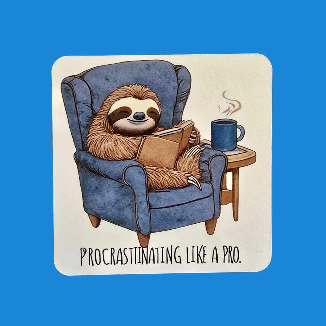 A square sticker or print with rounded corners featuring an illustration of a sloth lounging in a blue armchair and reading a book, with a blue mug on a small side table. The text below reads 'PROCRASTINATING LIKE A PRO.