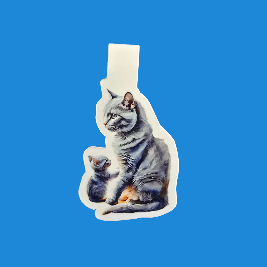 A die-cut sticker featuring a realistic illustration of a gray tabby cat and a small kitten, shown on a solid blue background.
