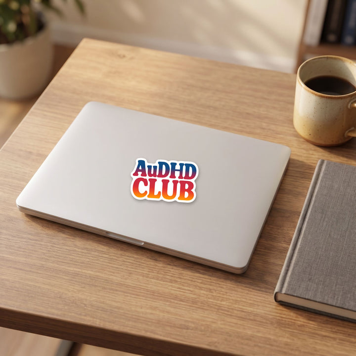 AuDHD CLUB sticker on a laptop