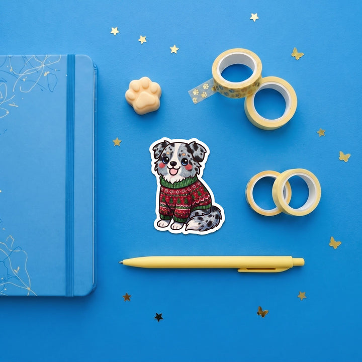 Blue merle Australian Shepherd ugly Christmas sweater 3 inch sticker flat lay with blue and yellow stationery – Designs by Mysh