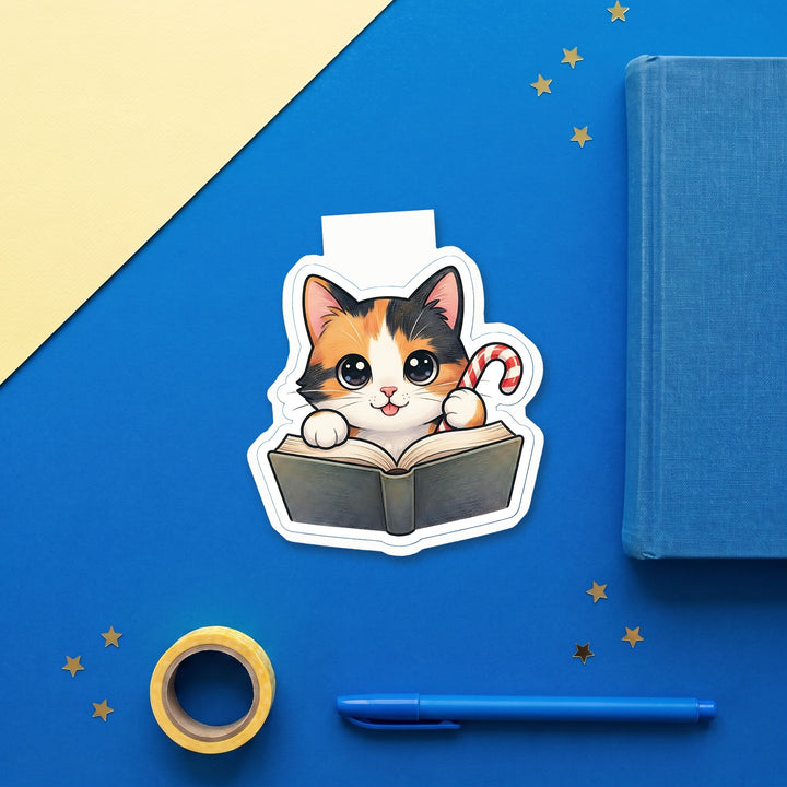 Calico cat with candy cane kawaii magnetic bookmark flat lay with blue stationery – Designs by Mysh
