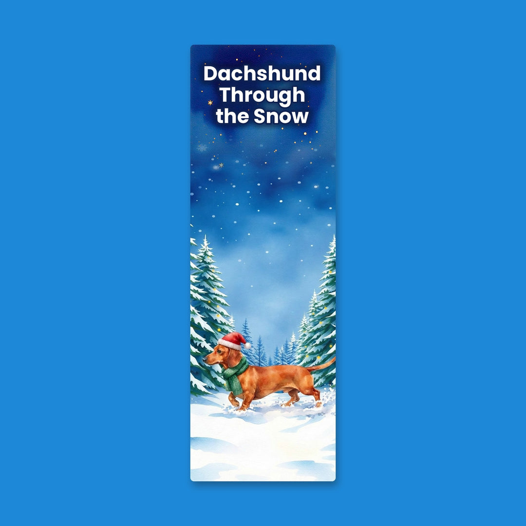 Dachshund Through the Snow watercolor bookmark with red Dachshund in Santa hat in snowy forest – Designs by Mysh