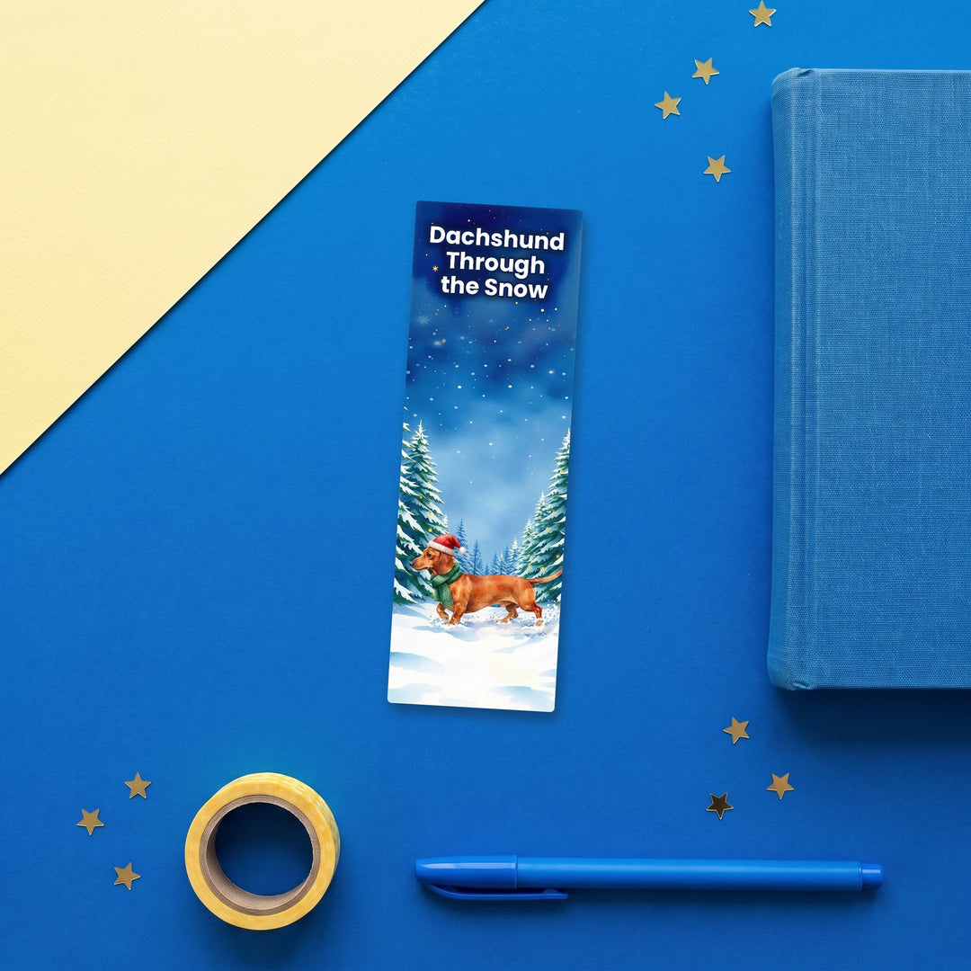 Dachshund Through the Snow watercolor bookmark flat lay with blue stationery – Designs by Mysh