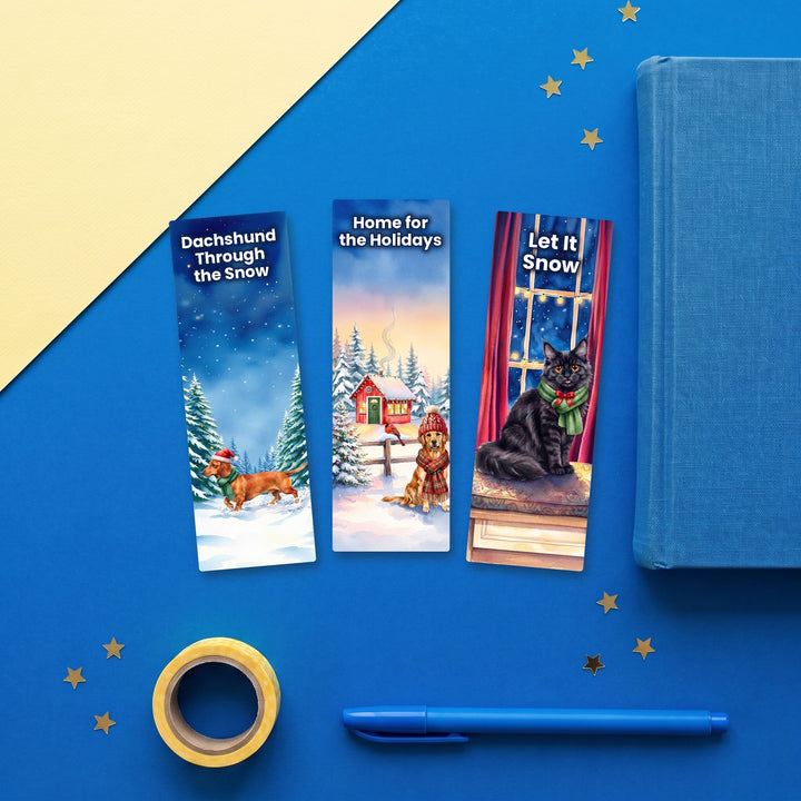 Set of 3 winter watercolor pet bookmarks: Dachshund, Golden Retriever and Maine Coon flat lay with blue stationery – Designs by Mysh
