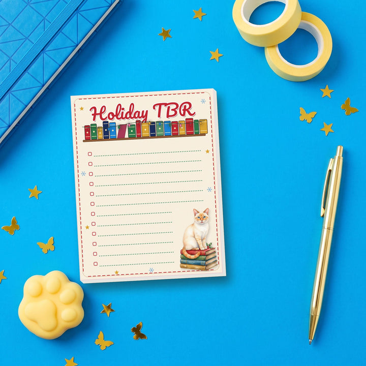 Holiday TBR notepad flat lay with blue and yellow stationery – Designs by Mysh