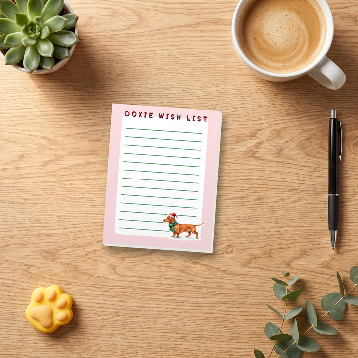 Doxie Wish List 4.25 x 5.5 notepad on a cozy desk with coffee and a pen for scale – Designs by Mysh