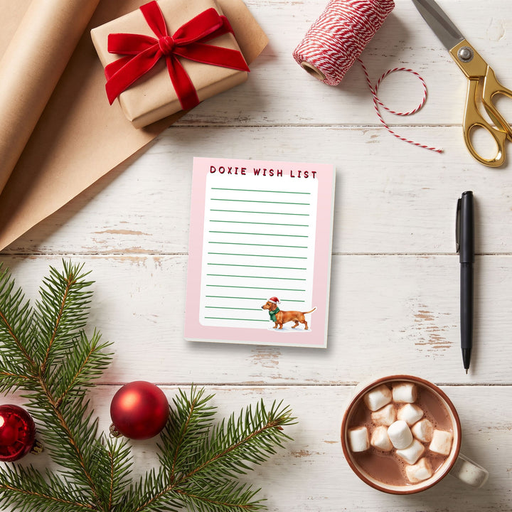 Doxie Wish List notepad on a Christmas gift-wrapping table – Designs by Mysh