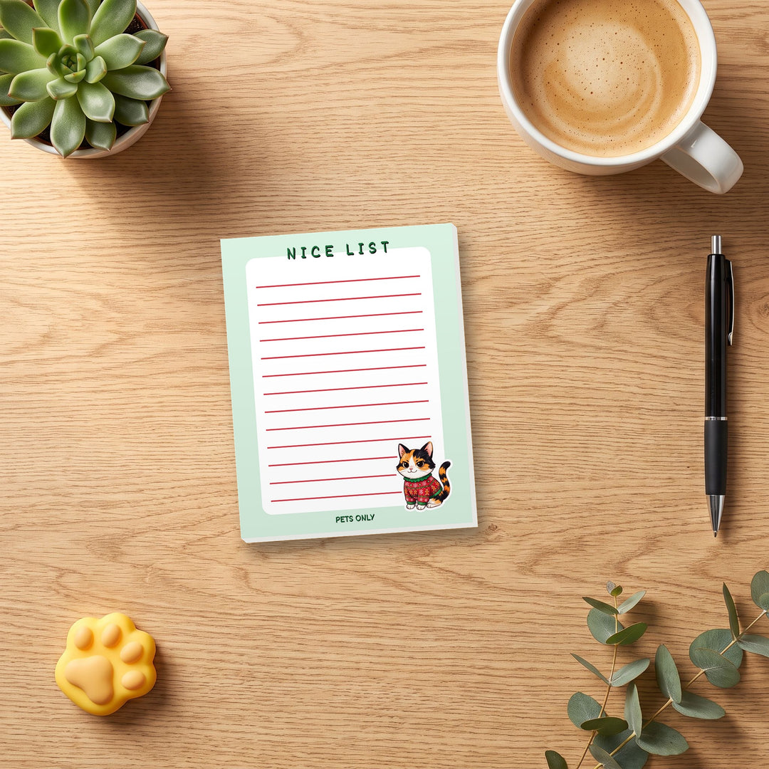 Nice List Pets Only 4.25 x 5.5 notepad on a cozy desk with coffee and a pen for scale – Designs by Mysh