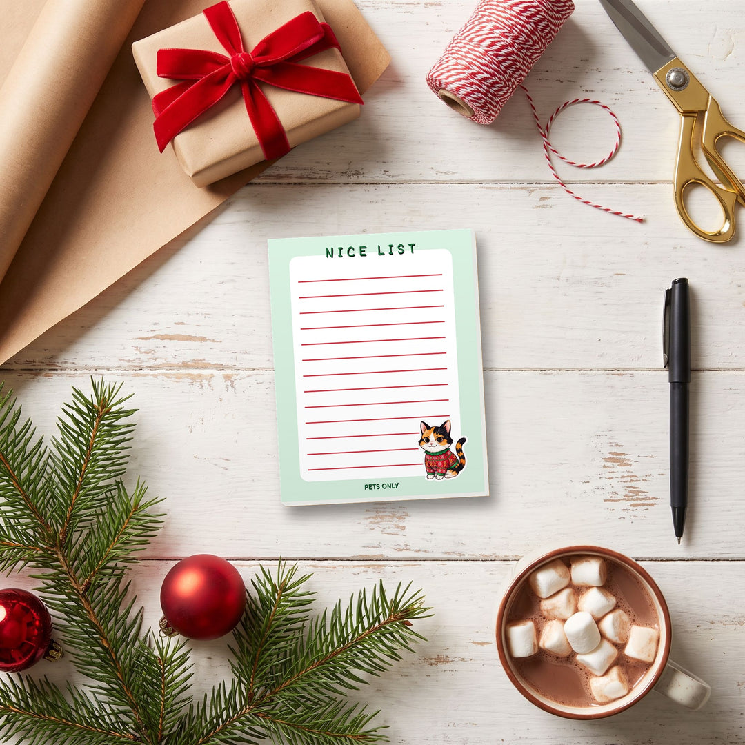 Nice List Pets Only notepad on a Christmas gift-wrapping table – Designs by Mysh