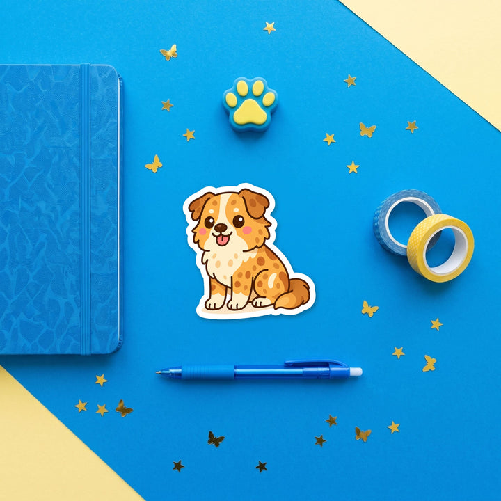 Australian Shepherd Red Merle kawaii 3 inch sticker flat lay with blue and yellow stationery – Designs by Mysh