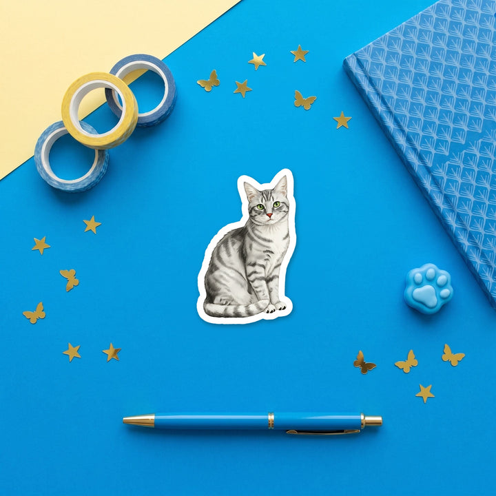 American Shorthair Silver Tabby watercolor 3 inch sticker flat lay with blue and yellow stationery – Designs by Mysh